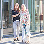 Eine jüngere und eine ältere Frau, Tochter und Mutter, stehen mit einem kleinen Hund an der Leine vor dem Eingang der Pflegeeinrichtung in Albersloh.